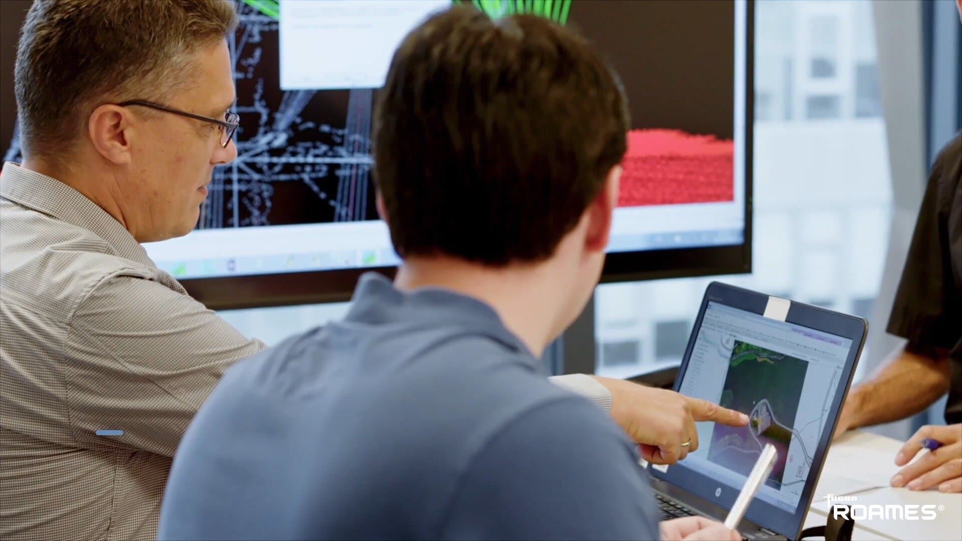 People looking at ROAMES data on a computer screen