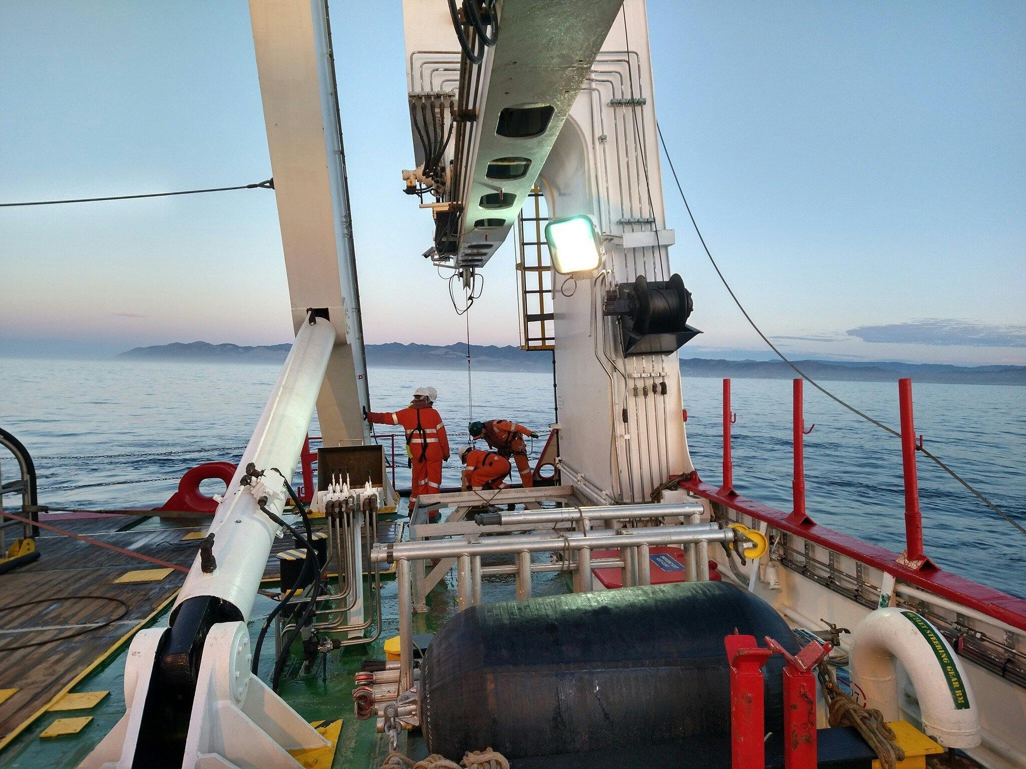 Seabed sampling with van Veen grab off the Fugro Discovery. Geologist is checking the sample quality