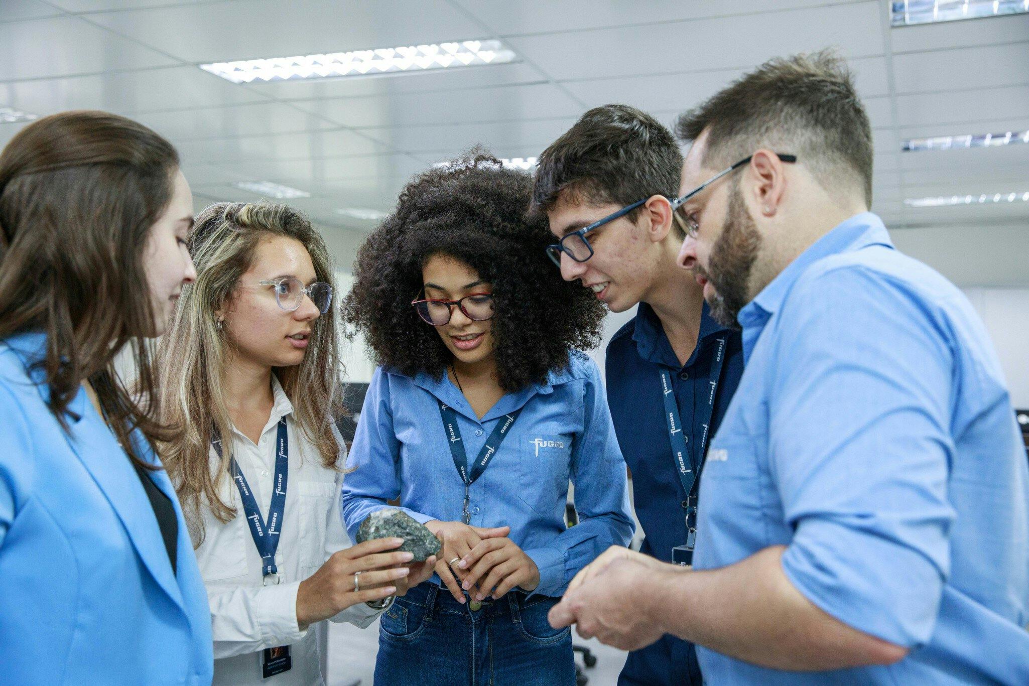 Employees discussing a rock sample in the Curitiba office in Brazil